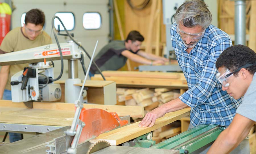 trade school teacher teaching students in woodworking