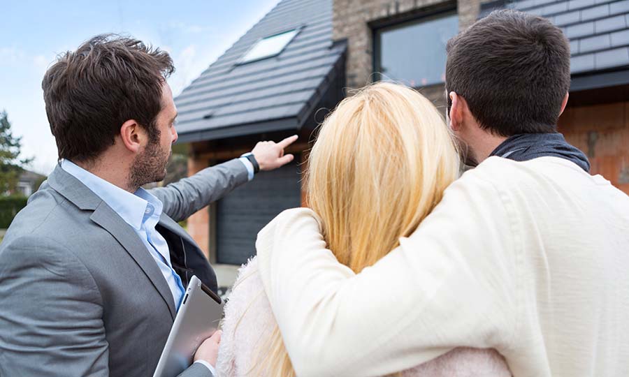 young family looking at new home construction